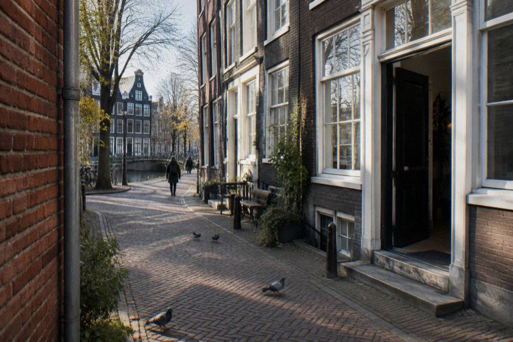 Narrow Amsterdam street with canal houses and a hostel entrance