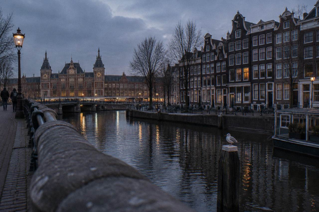 Canal houses and a bridge over an Amsterdam canal at dusk