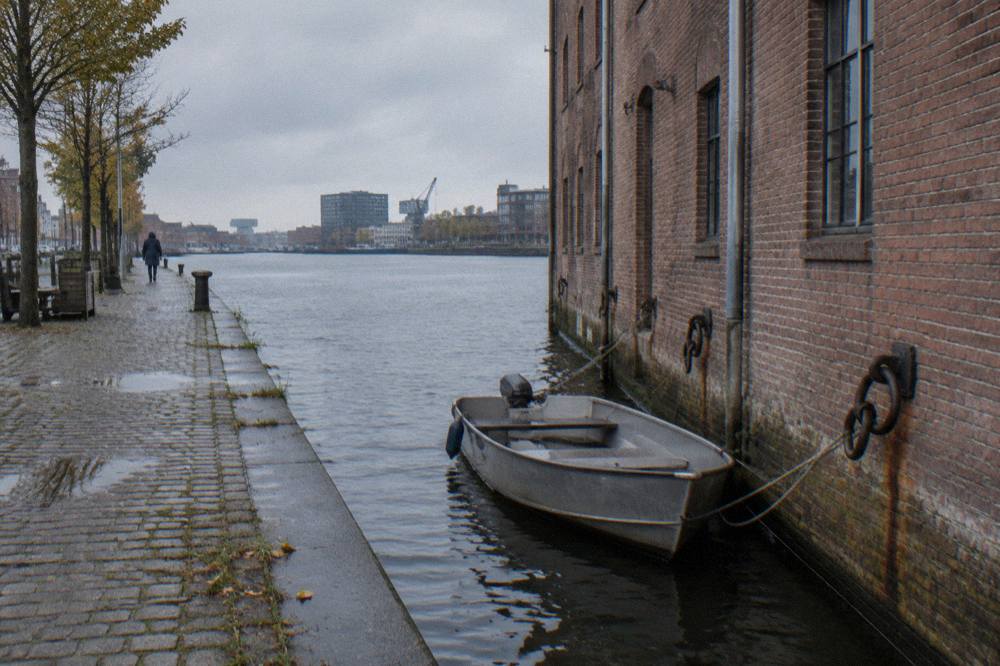 Canal-side street in Amsterdam Noord with brick buildings and bicycles parked along the water