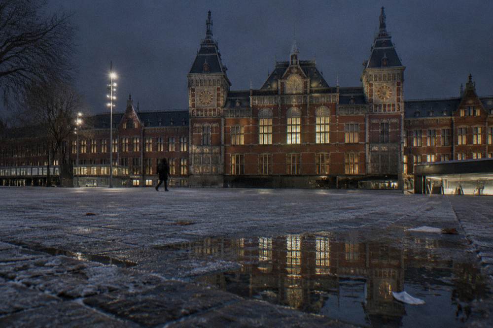 Amsterdam Centraal station facade lit up at night with empty square