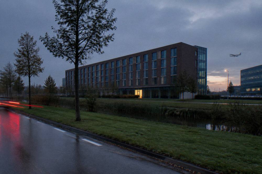 Row of modern budget hotel buildings along a road near the airport at evening