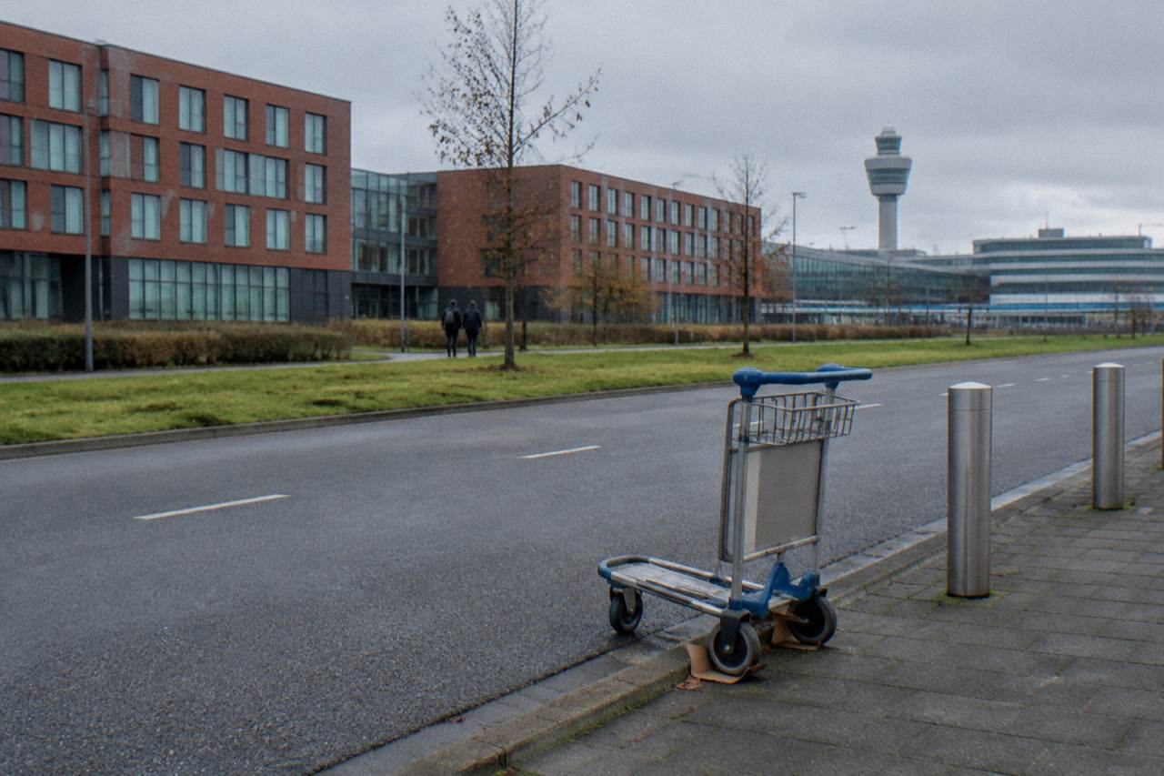 Hotel buildings and a quiet road beside Schiphol Airport under an overcast sky