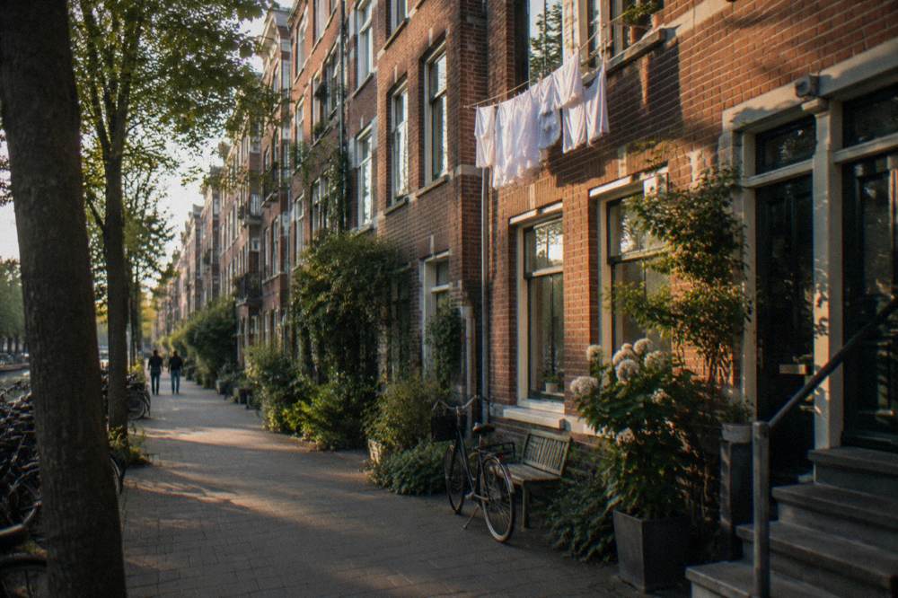 Amsterdam residential street with parked bicycles and brick facades in soft evening light