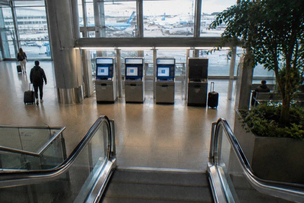 Ticket machines and departure boards in the station hall beneath the airport terminal