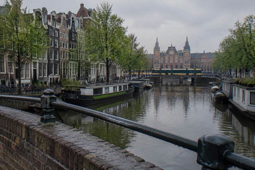 Bicycles parked along a canal bridge in Amsterdam on an overcast morning