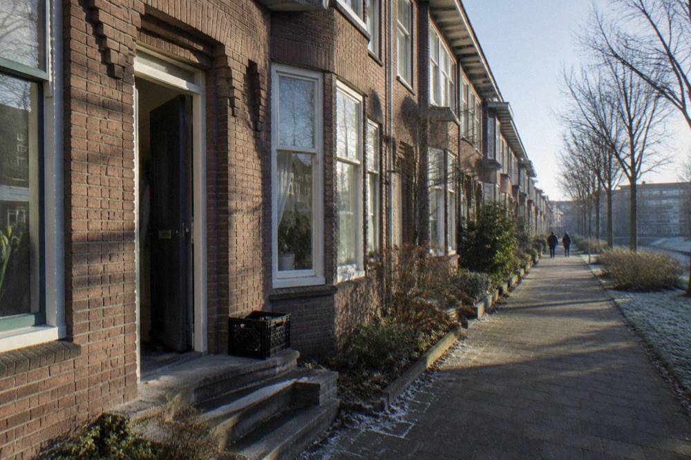 A quiet residential street of brick row houses in a neighbourhood outside the Amsterdam centre