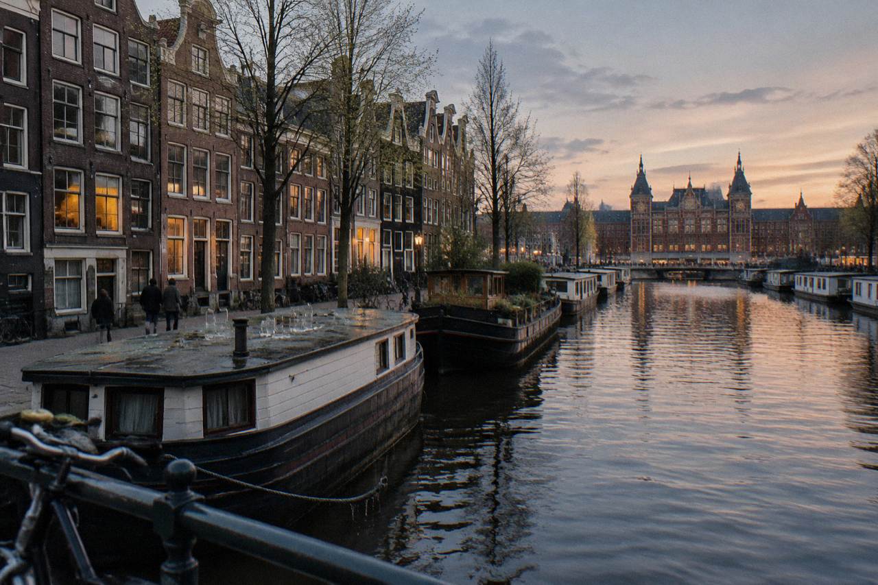 Canal houses and moored boats along a quiet Amsterdam gracht at dusk