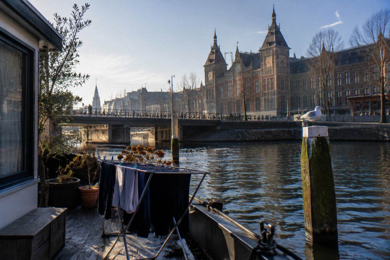 A canal-side row of narrow Amsterdam houses with bicycles parked along the water
