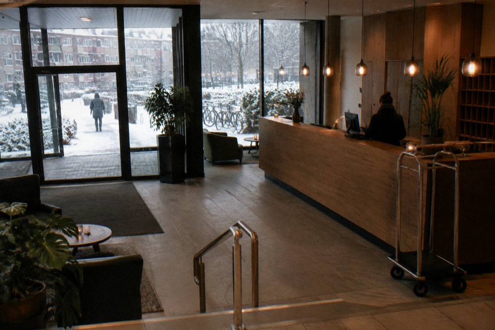 A hotel reception desk with warm lighting and a wooden counter
