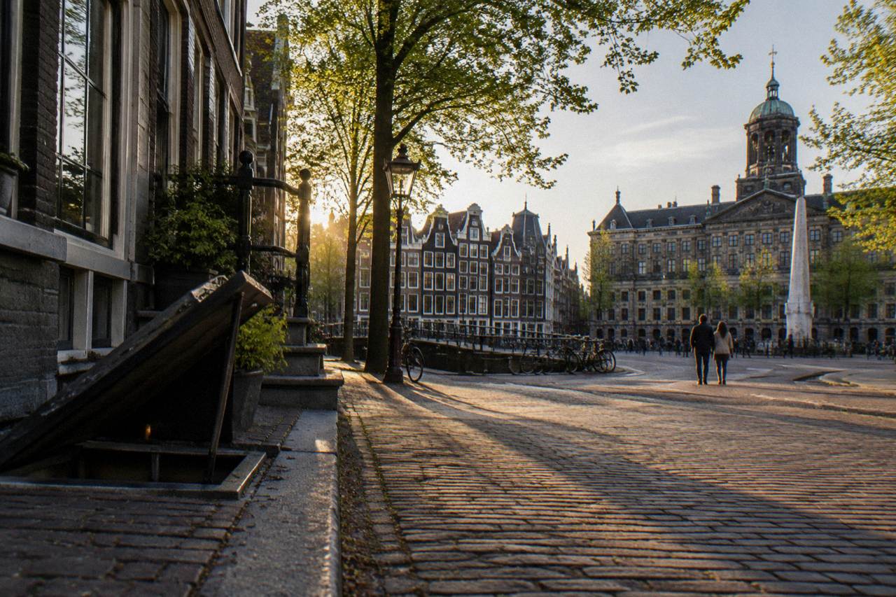 Canal houses and bicycles along a quiet Amsterdam street in evening light