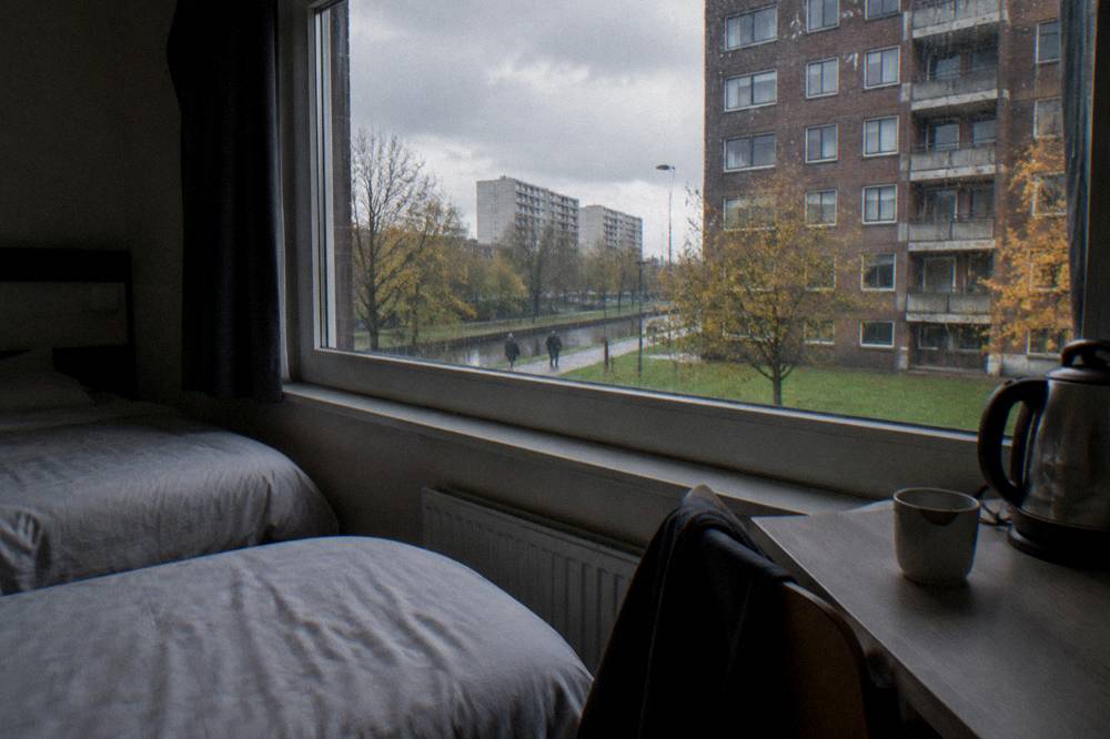 A small modern hotel room with two single beds and a window