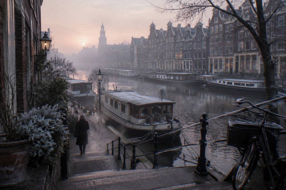 Dense Amsterdam canal houses seen from a bridge in evening light