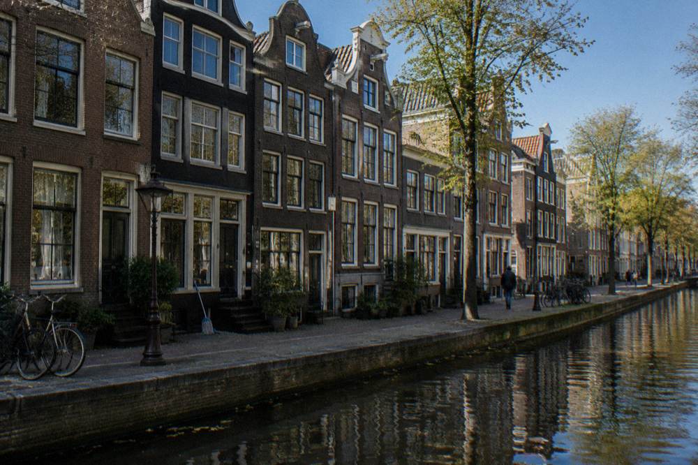 Narrow canal street with tall gabled houses and bicycles in central Amsterdam