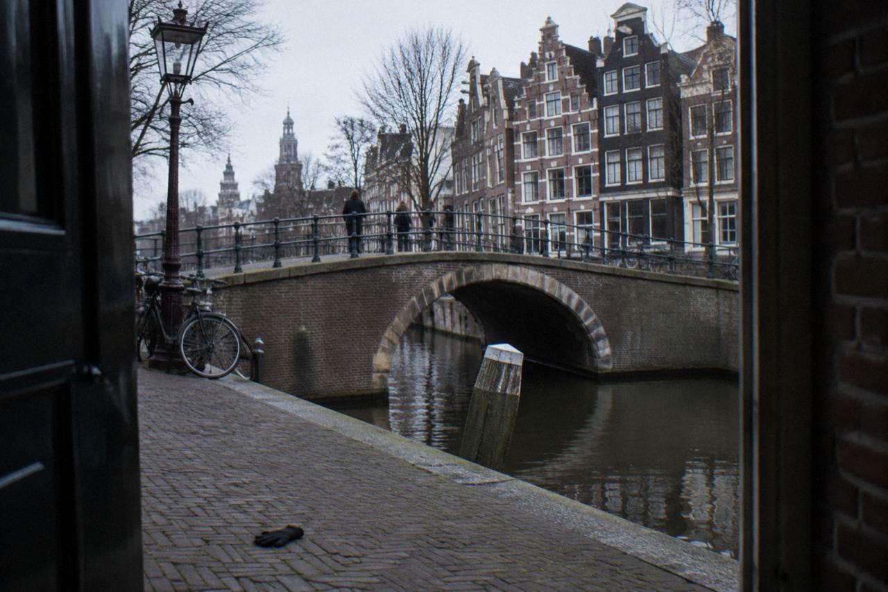 Canal houses and a bridge over quiet water in a central Amsterdam neighbourhood