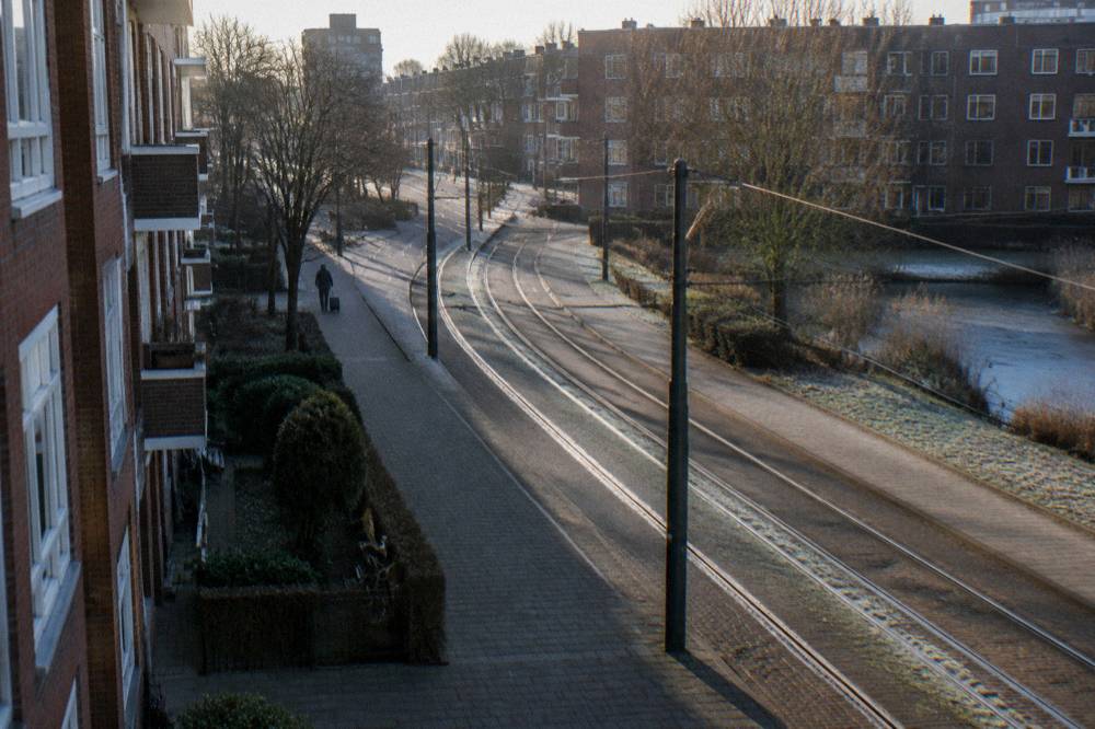 Amsterdam tram track curving along a residential street with brick apartment blocks