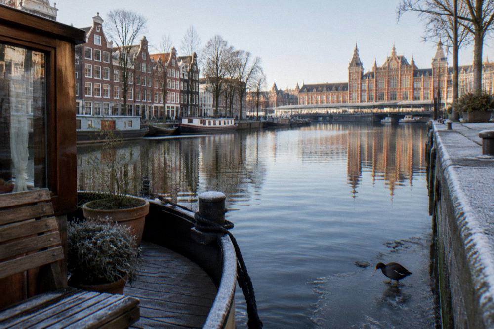 Canal houses reflected in still water on a quiet winter morning