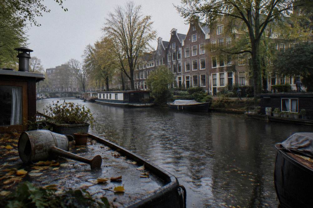 Row of narrow brick houses along a canal in Amsterdam West