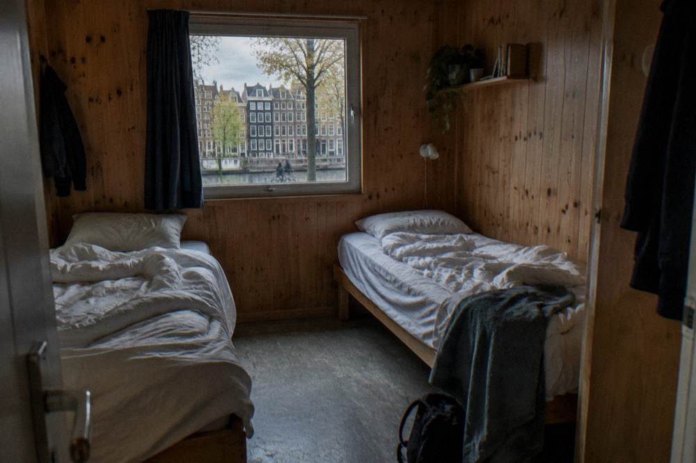 Interior of a compact wooden cabin with two single beds and a small window