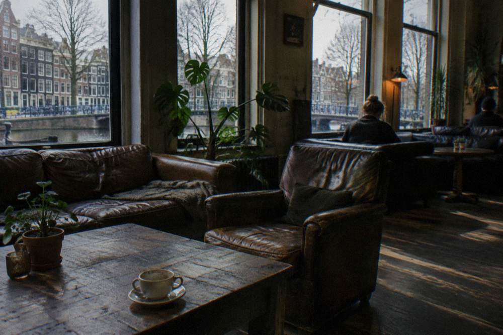 Amsterdam hostel common room with sofas and empty tables on a winter afternoon