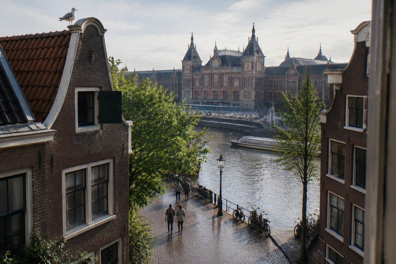 Quiet Amsterdam canal street with narrow gabled houses and parked bicycles