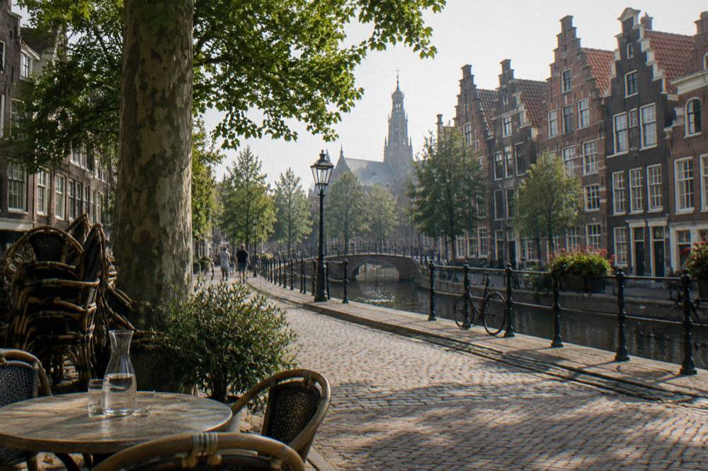 Gabled brick facades and a café terrace on a narrow street in old Haarlem