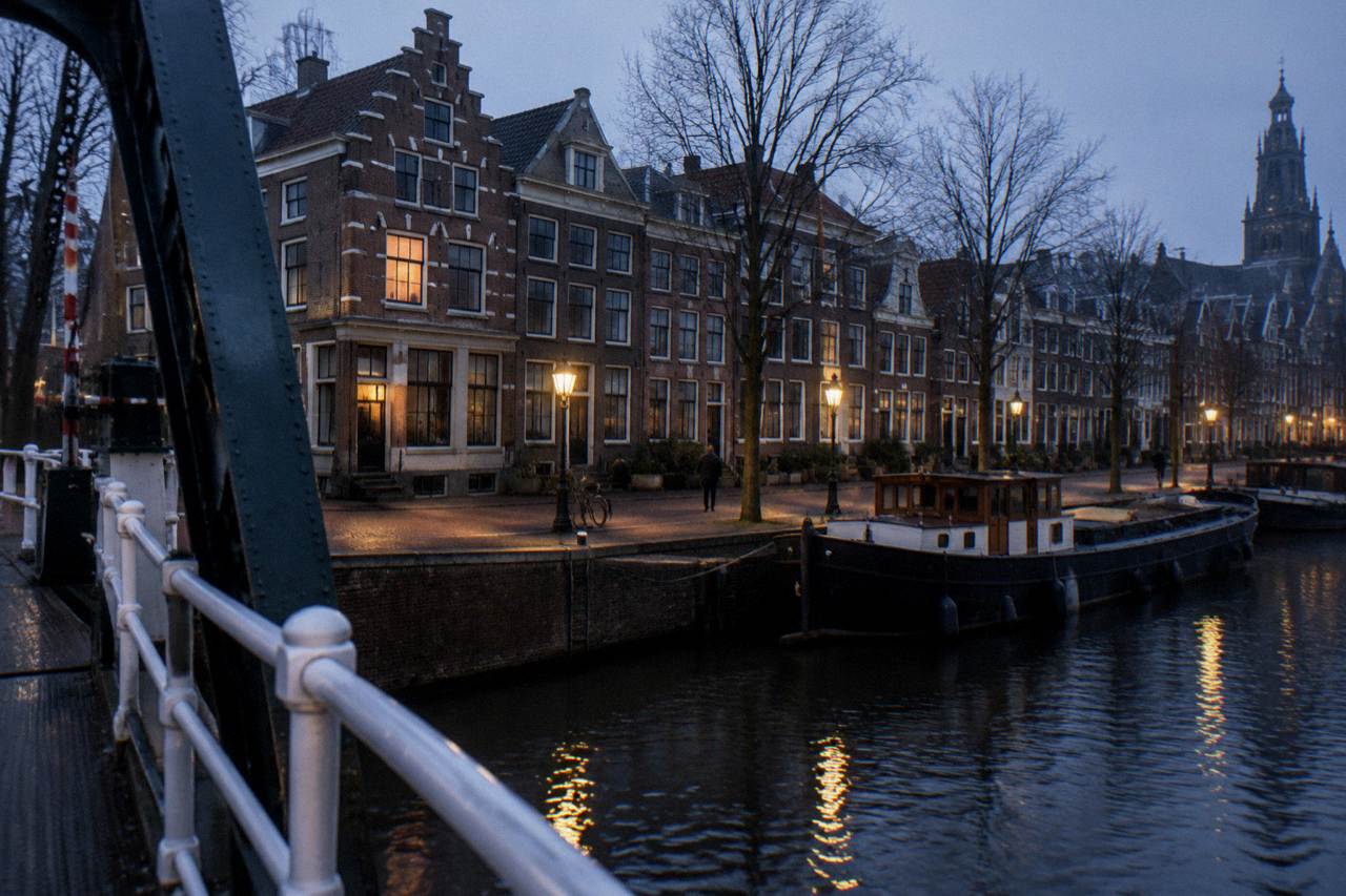 Canal houses and a small riverfront street in a Dutch town outside Amsterdam at dusk