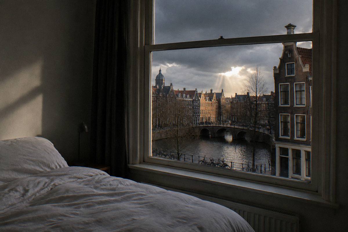A plain tidy double room with a window over brick rooftops