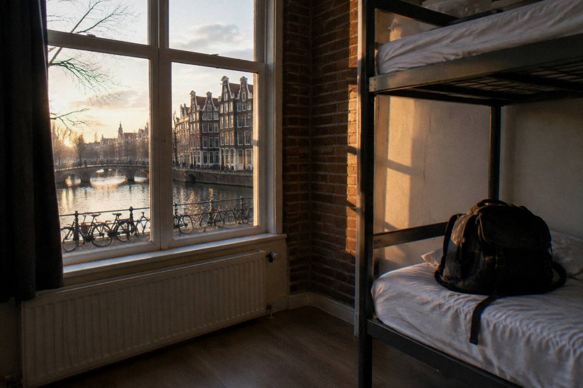 A backpack on a bunk bed in a plain shared room